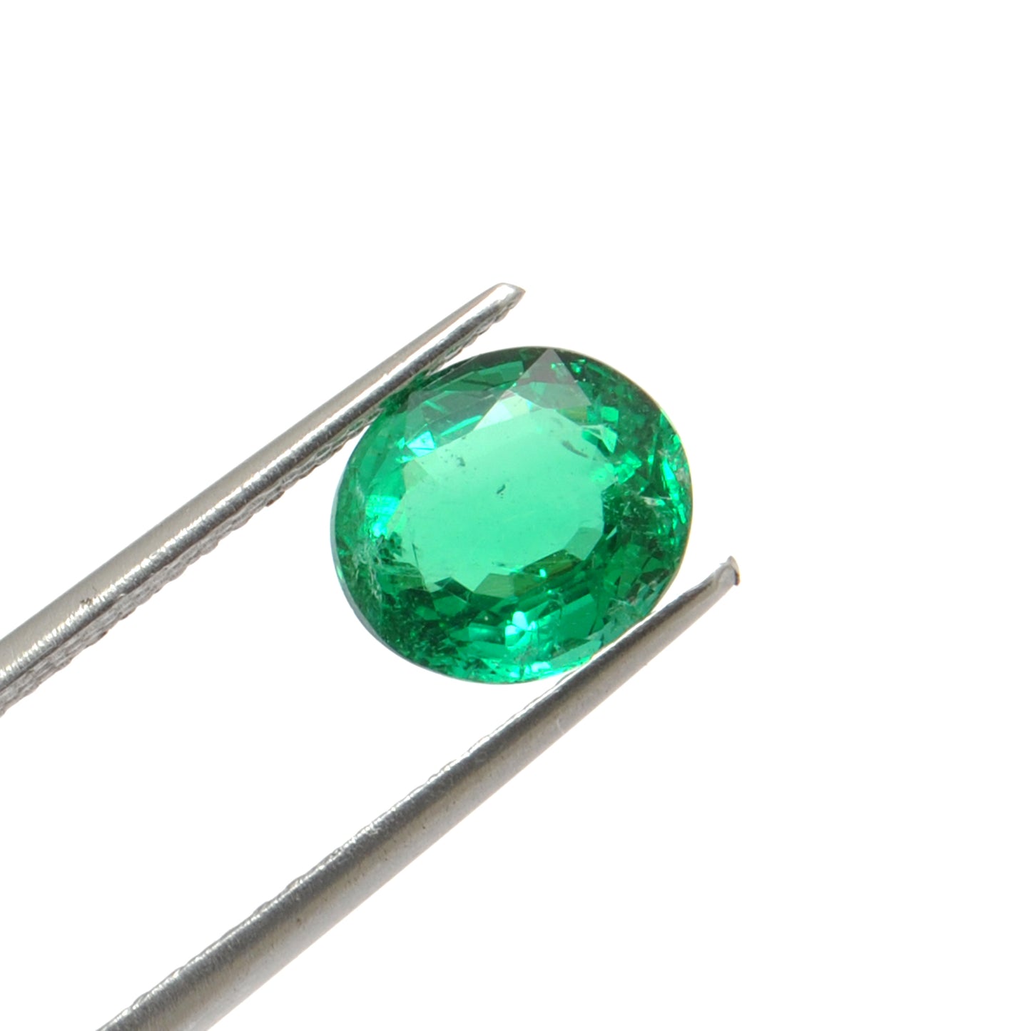 Close-up of a Kanika Creations natural Zambian emerald gemstone, 3.05 carats, oval faceted cut, 8.5x9.5mm, showcasing rich green color and stunning clarity.