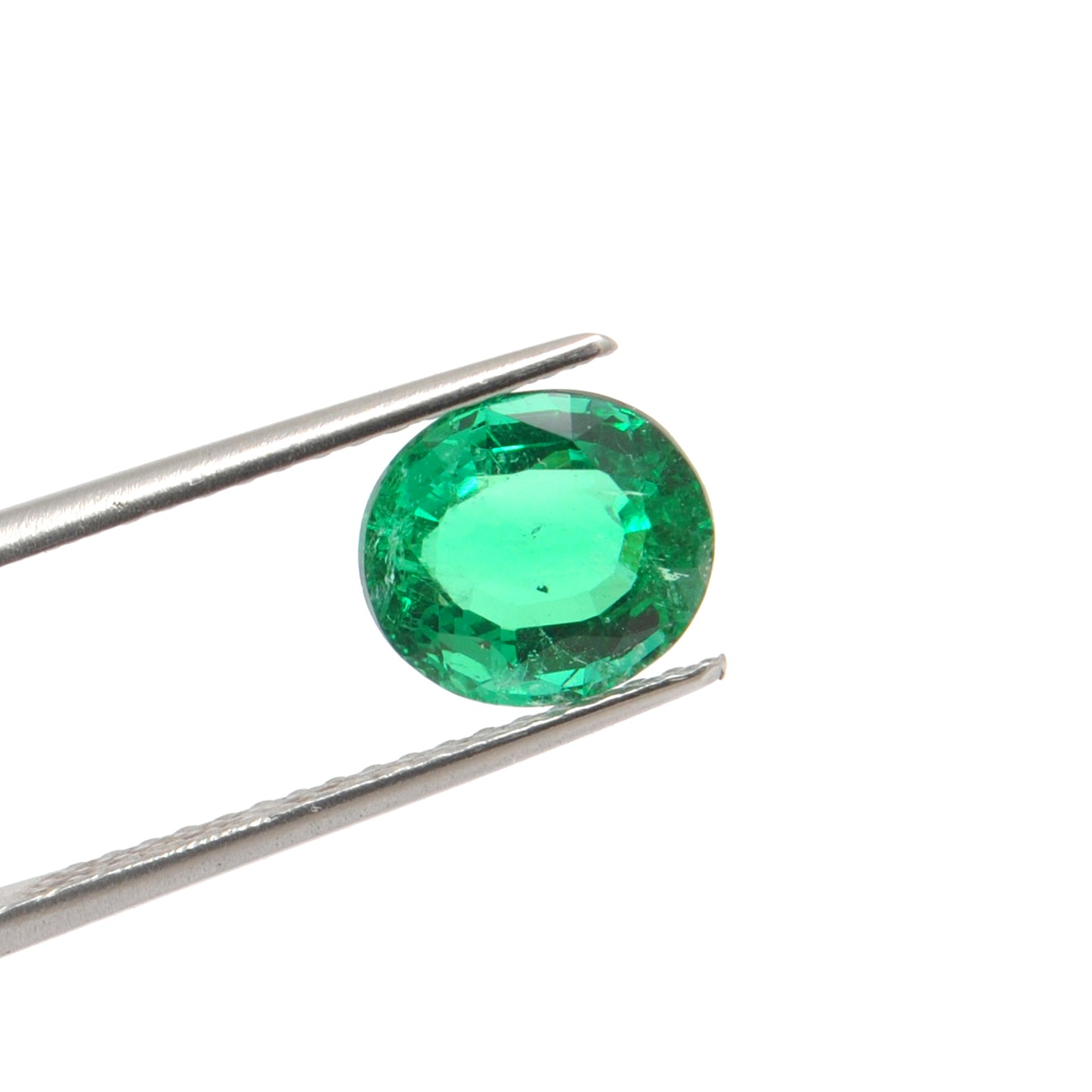 Close-up of a Kanika Creations natural Zambian emerald gemstone, 3.05 carats, oval faceted cut, 8.5x9.5mm, showcasing rich green color and stunning clarity.