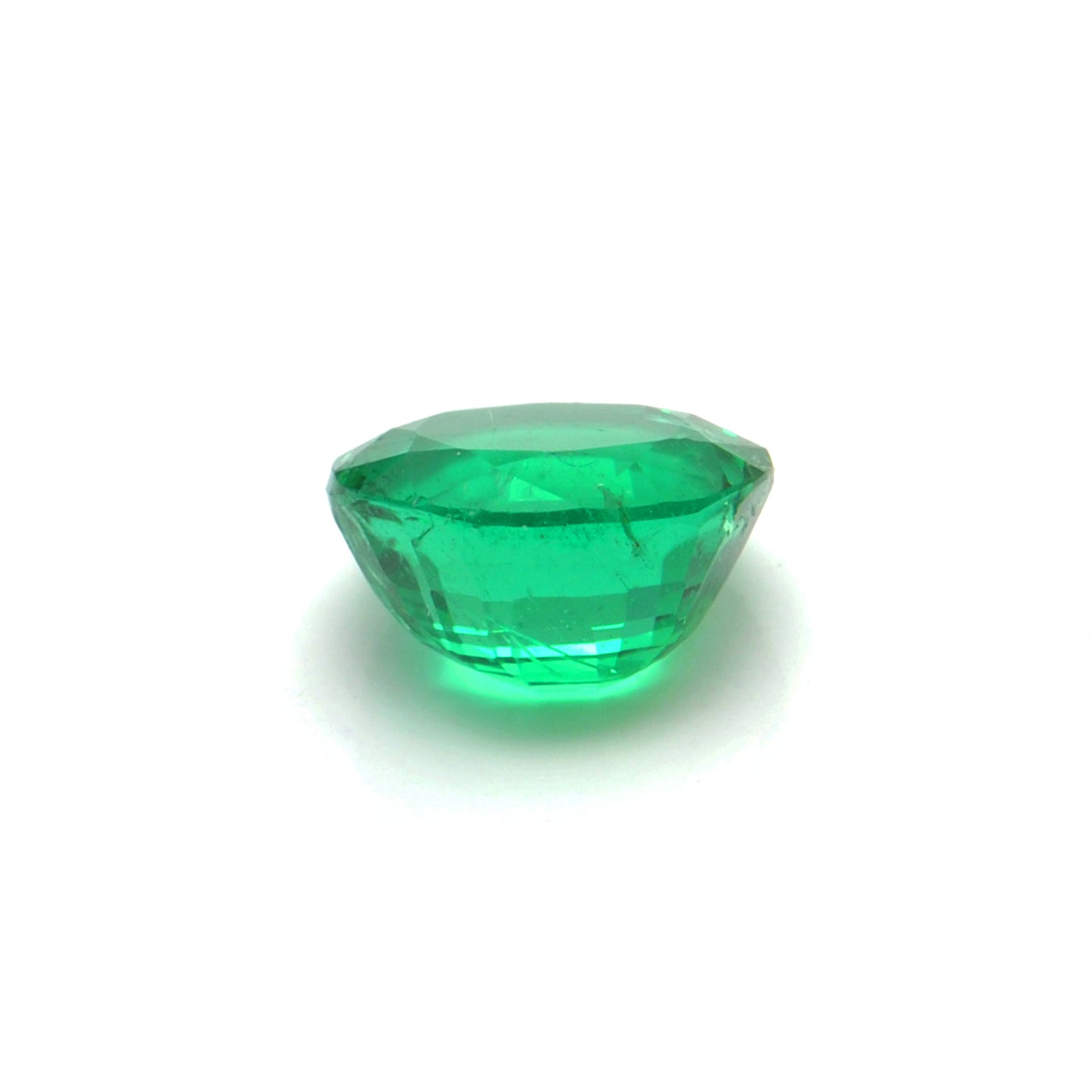 Close-up of a Kanika Creations natural Zambian emerald gemstone, 3.05 carats, oval faceted cut, 8.5x9.5mm, showcasing rich green color and stunning clarity.