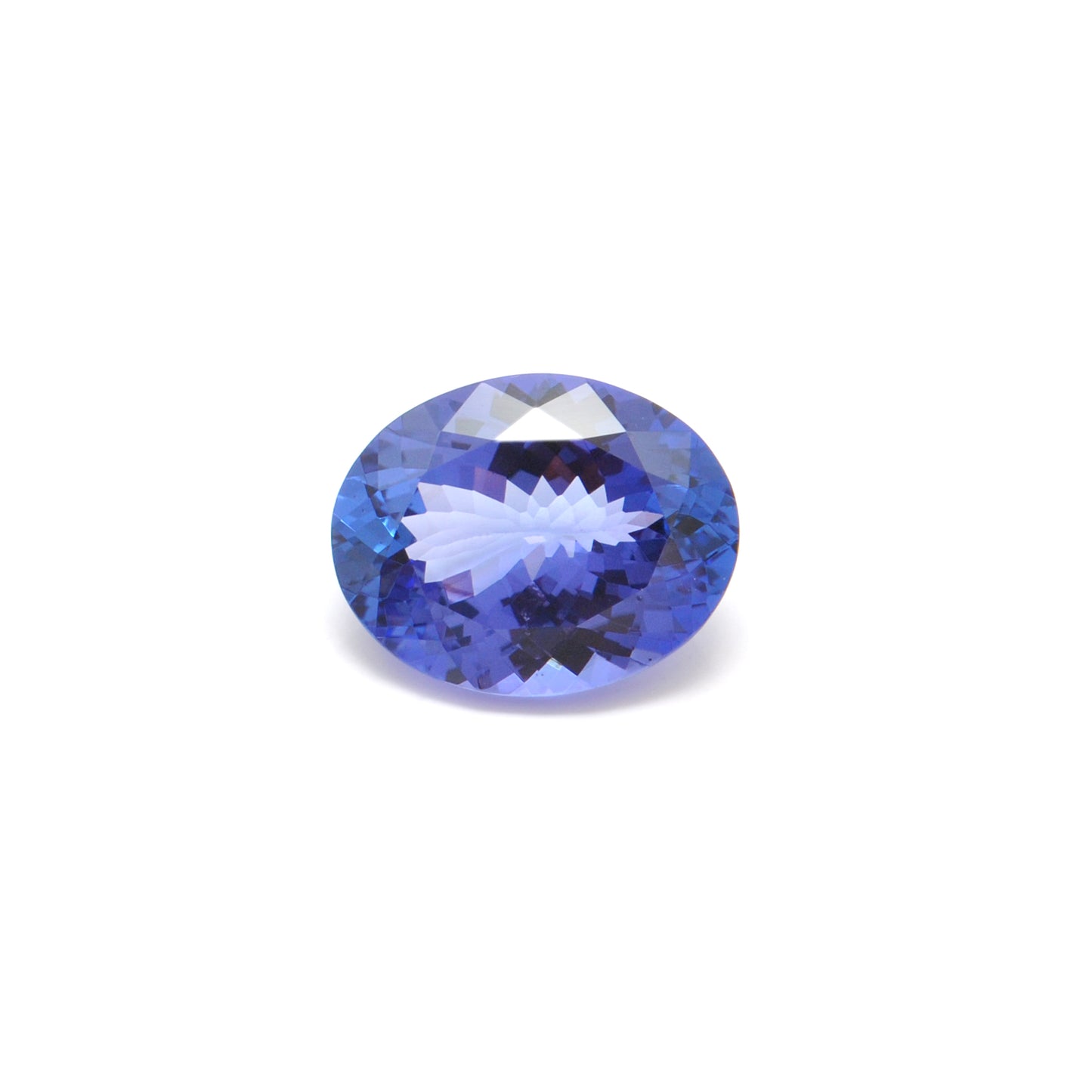 Close-up of a Kanika Creations natural tanzanite gemstone, 7.65 carats, faceted oval cut, 11.5x14.5mm, showcasing violet-blue color and brilliant clarity.