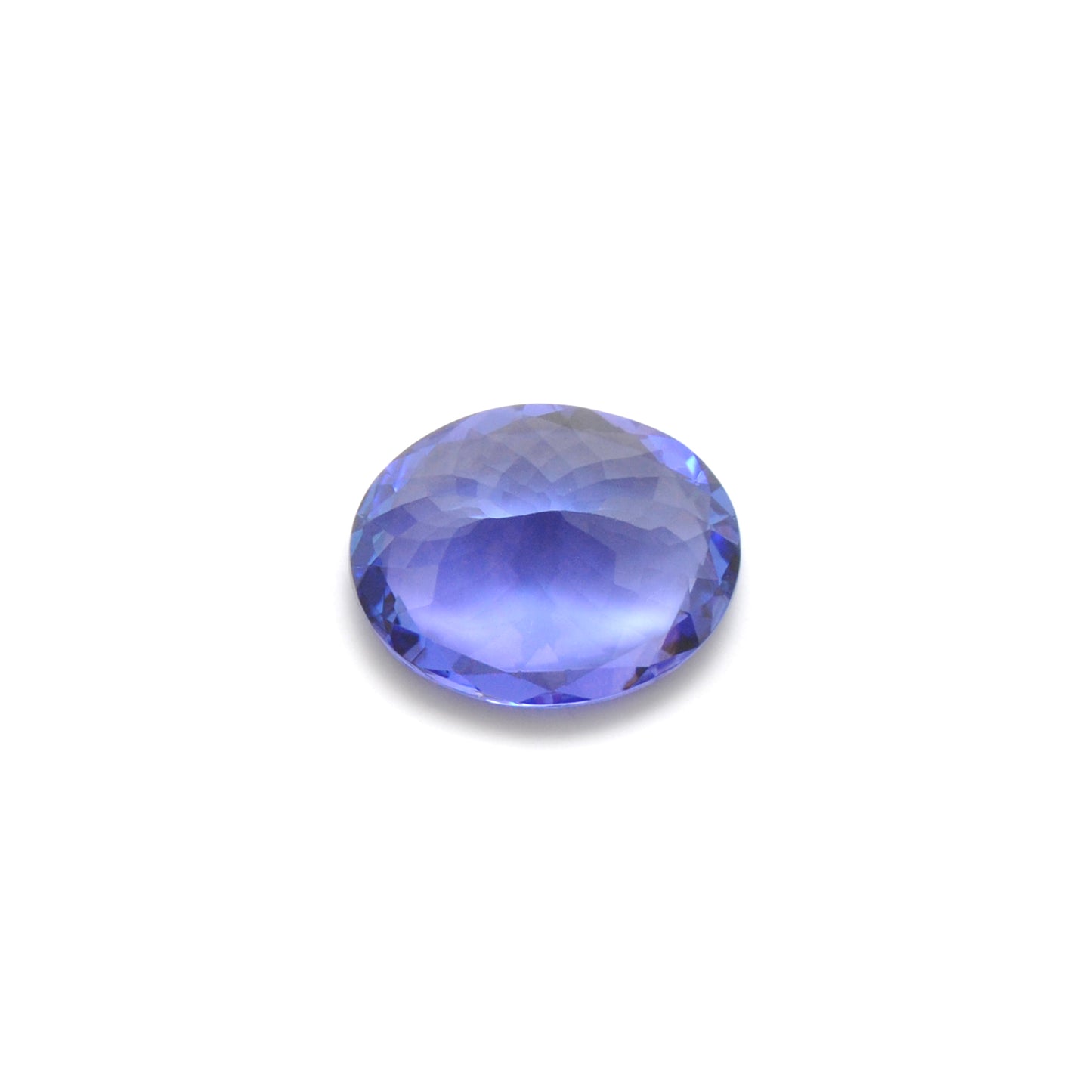 Close-up of a Kanika Creations natural tanzanite gemstone, 7.65 carats, faceted oval cut, 11.5x14.5mm, showcasing violet-blue color and brilliant clarity.