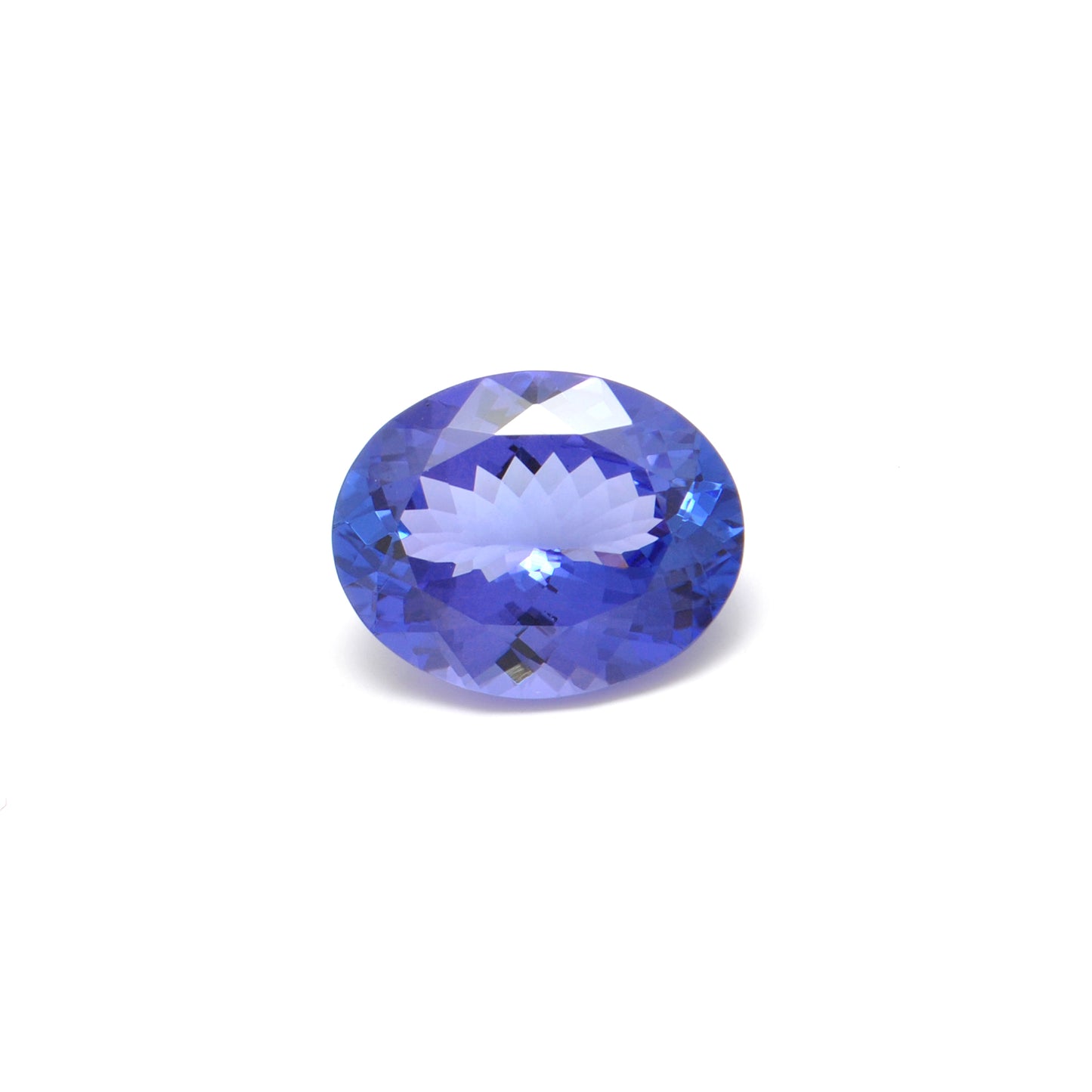 Close-up of a Kanika Creations natural tanzanite gemstone, 7.65 carats, faceted oval cut, 11.5x14.5mm, showcasing violet-blue color and brilliant clarity.