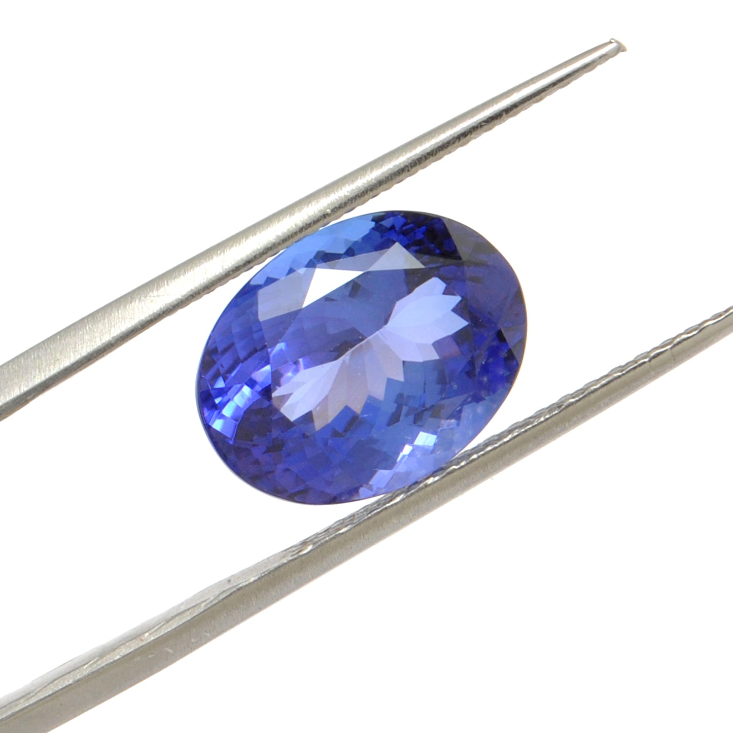 Close-up of a Kanika Creations natural tanzanite gemstone, 6.25 carats, faceted oval cut, 6x10mm, showcasing violet-blue color and brilliant clarity