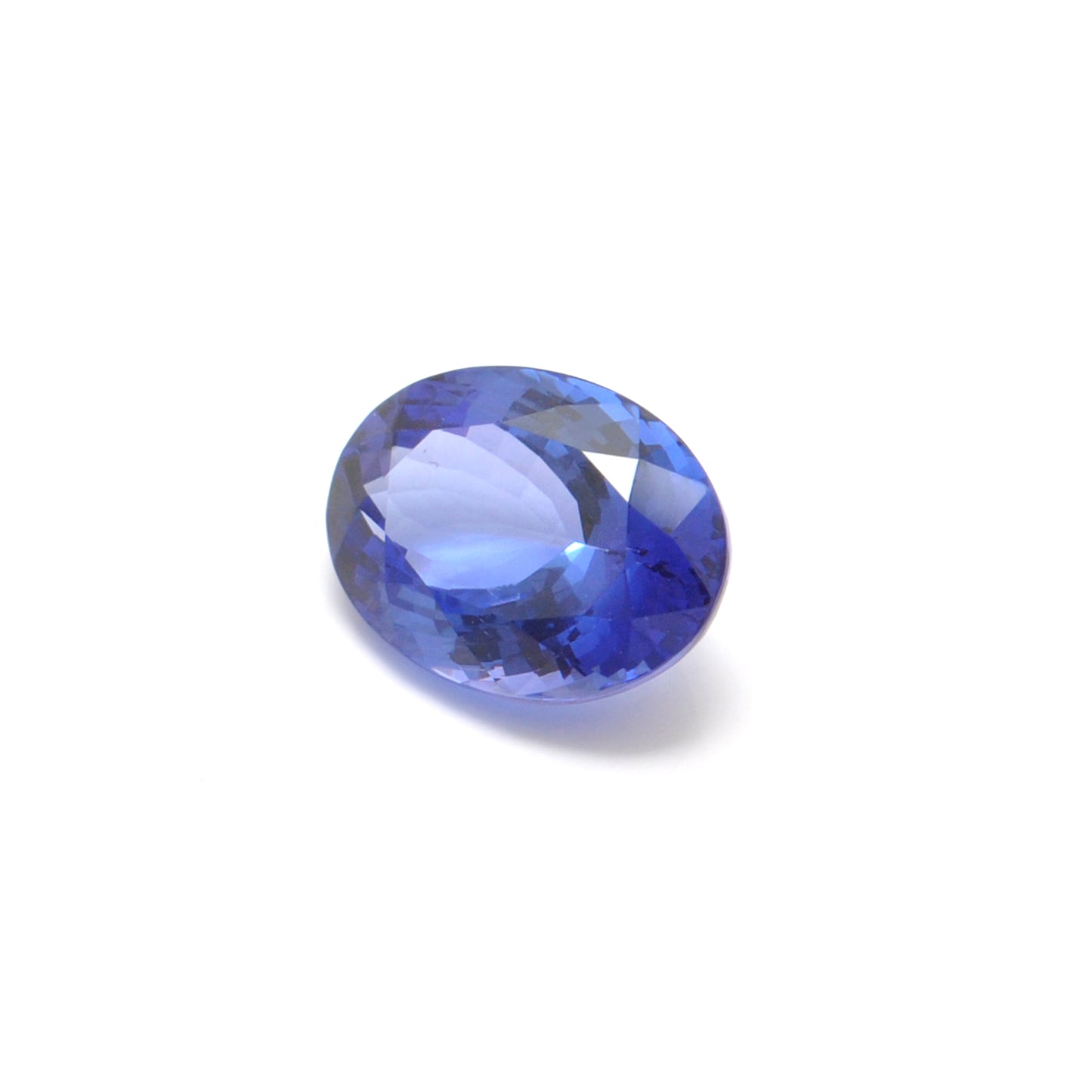 Close-up of a Kanika Creations natural tanzanite gemstone, 6.25 carats, faceted oval cut, 6x10mm, showcasing violet-blue color and brilliant clarity
