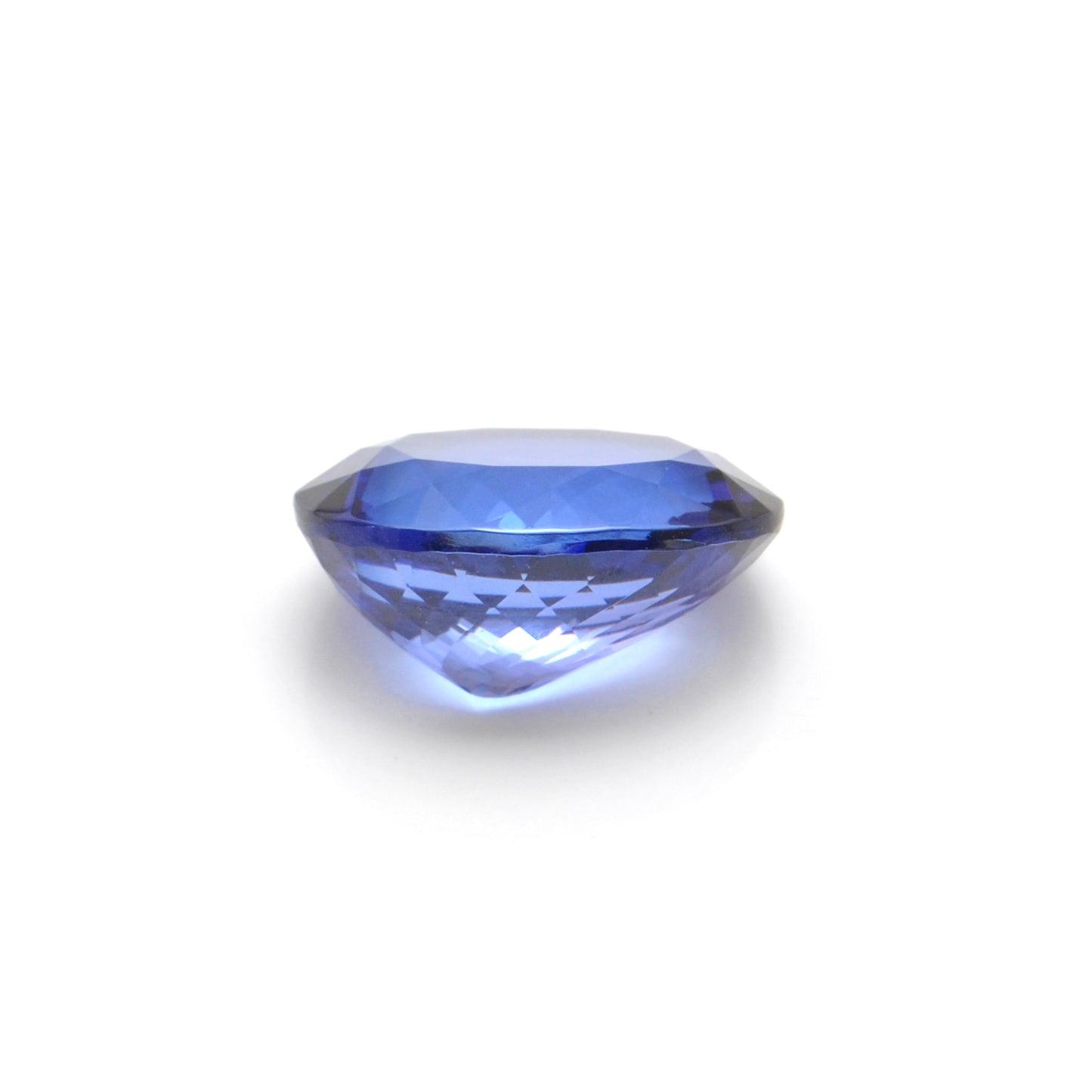 Close-up of a Kanika Creations natural tanzanite gemstone, 6.25 carats, faceted oval cut, 6x10mm, showcasing violet-blue color and brilliant clarity