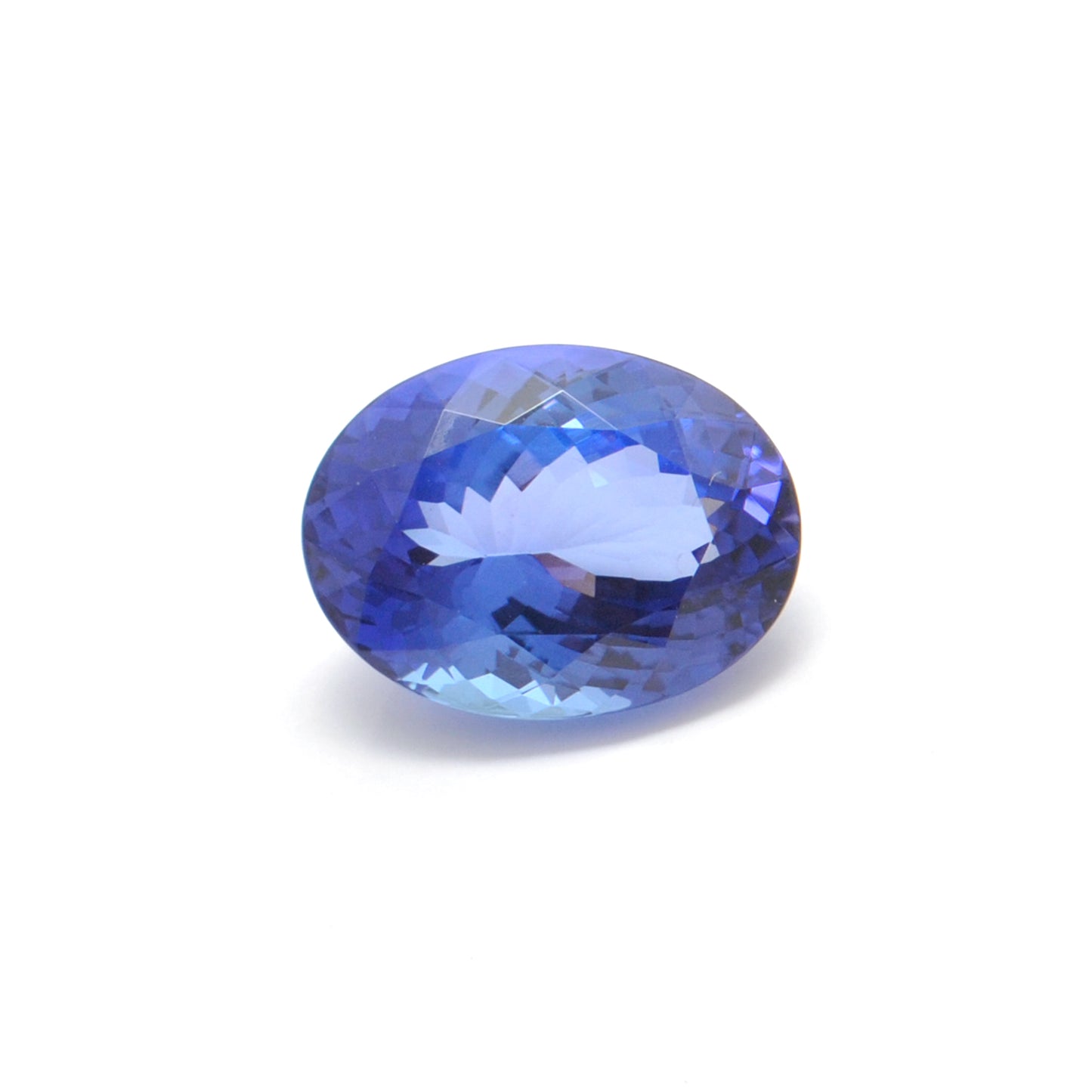 Close-up of a Kanika Creations natural tanzanite gemstone, 6.25 carats, faceted oval cut, 6x10mm, showcasing violet-blue color and brilliant clarity