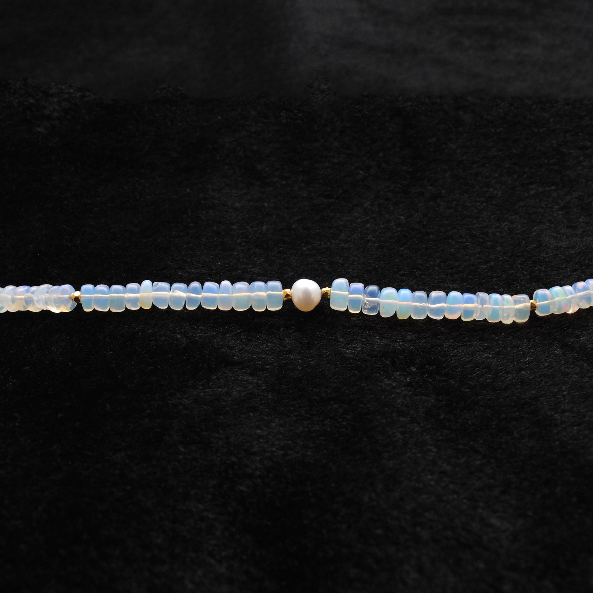 Beaded Necklace featuring 925 Sterling Silver, Opal beads, and Freshwater Pearl centerpiece on a black background.