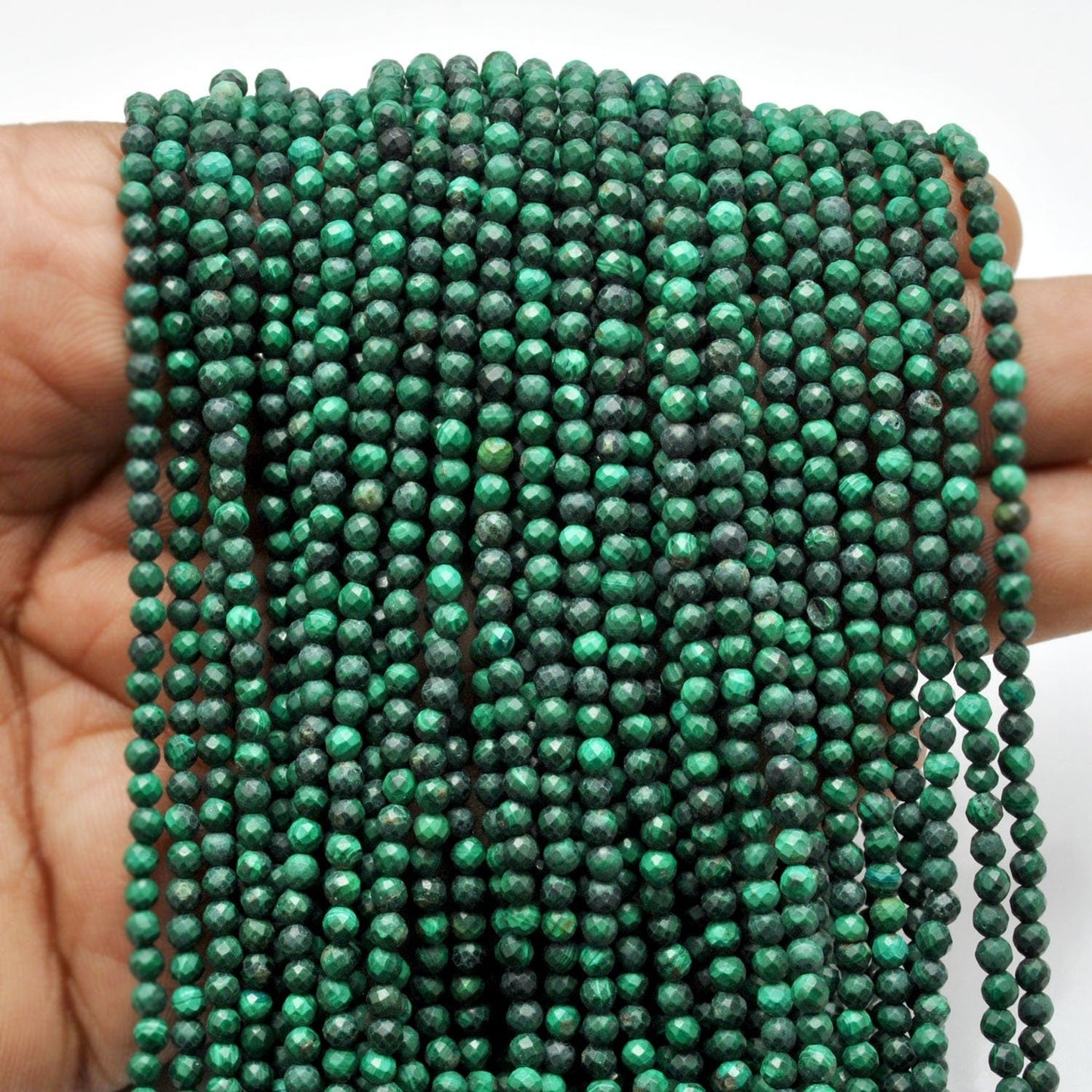 Natural malachite beads scattered loose - unique green patterns
