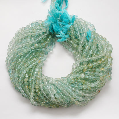 Aquamarine 6-6.5mm round beads scattered loose - premium grade view