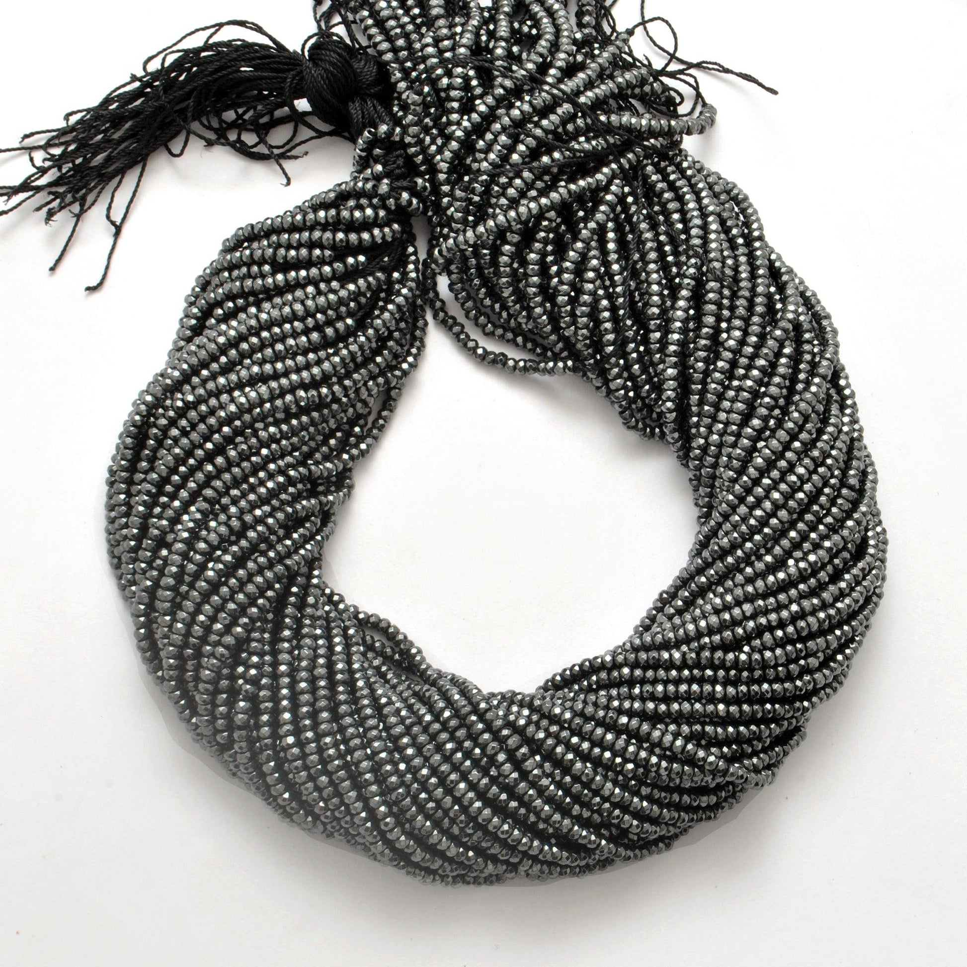 Black hematite rondelle beads strand - overhead flat lay dark view