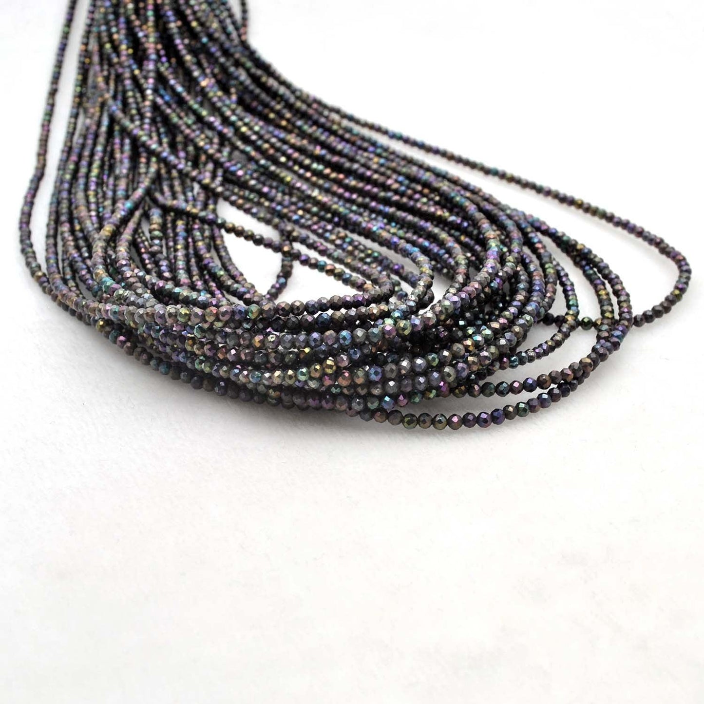 Black spinel coated round beads strand - overhead flat lay dark