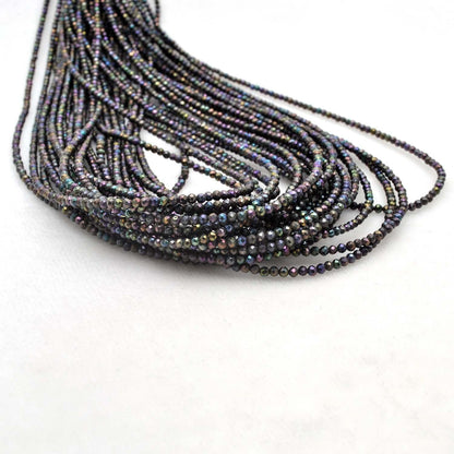 Black spinel coated round beads strand - overhead flat lay dark