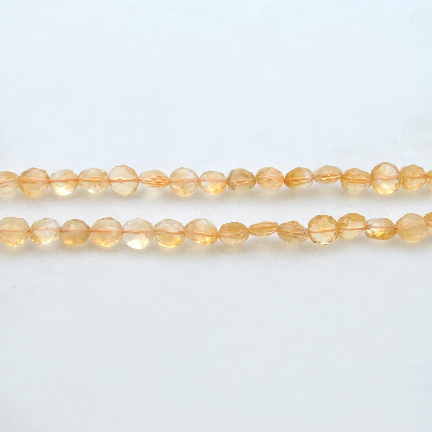 Citrine faceted coin beads scattered loose - golden range view