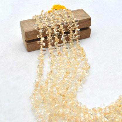 Citrine teardrop beads scattered loose - golden warm tones