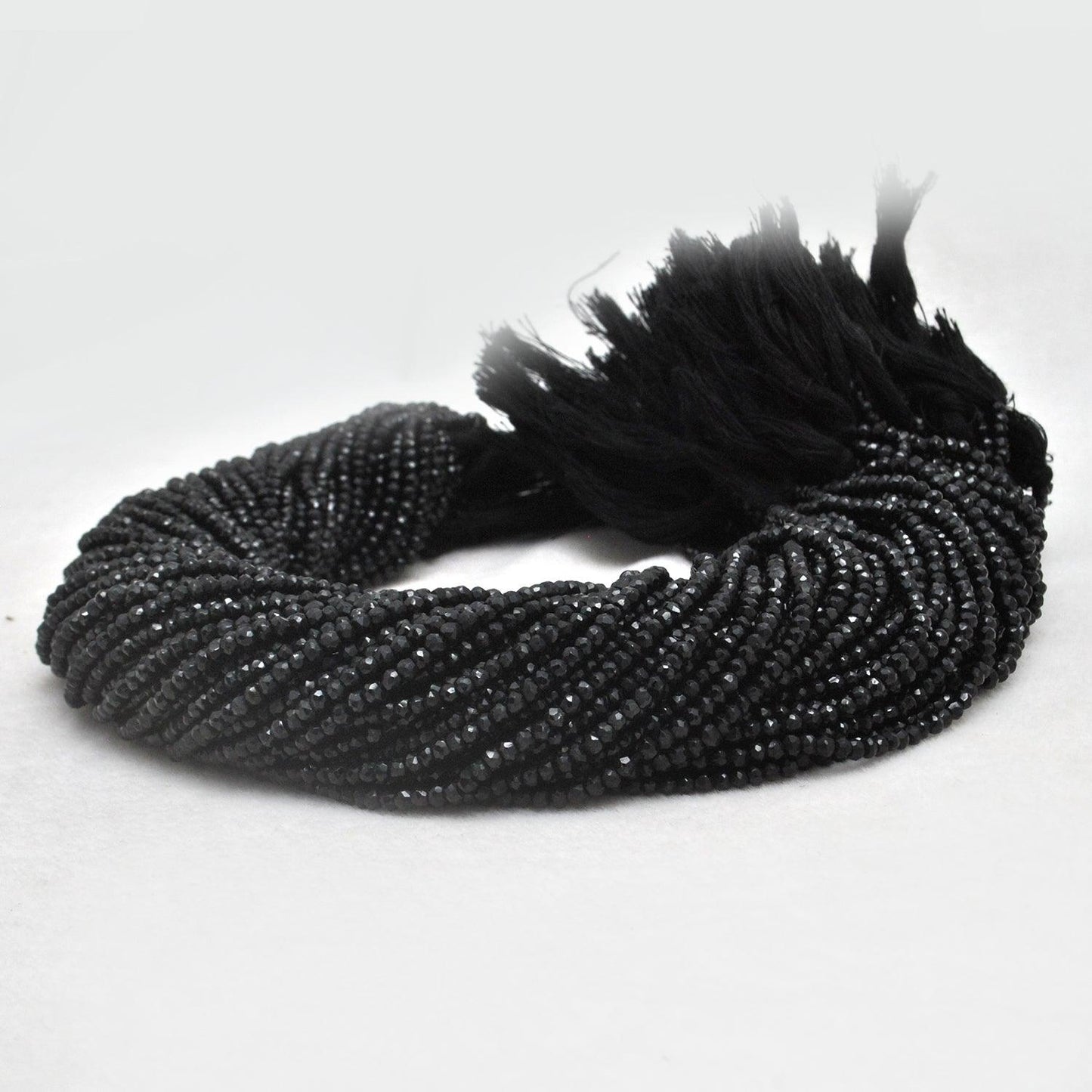 Natural black spinel rondelle beads strand - overhead flat lay dark
