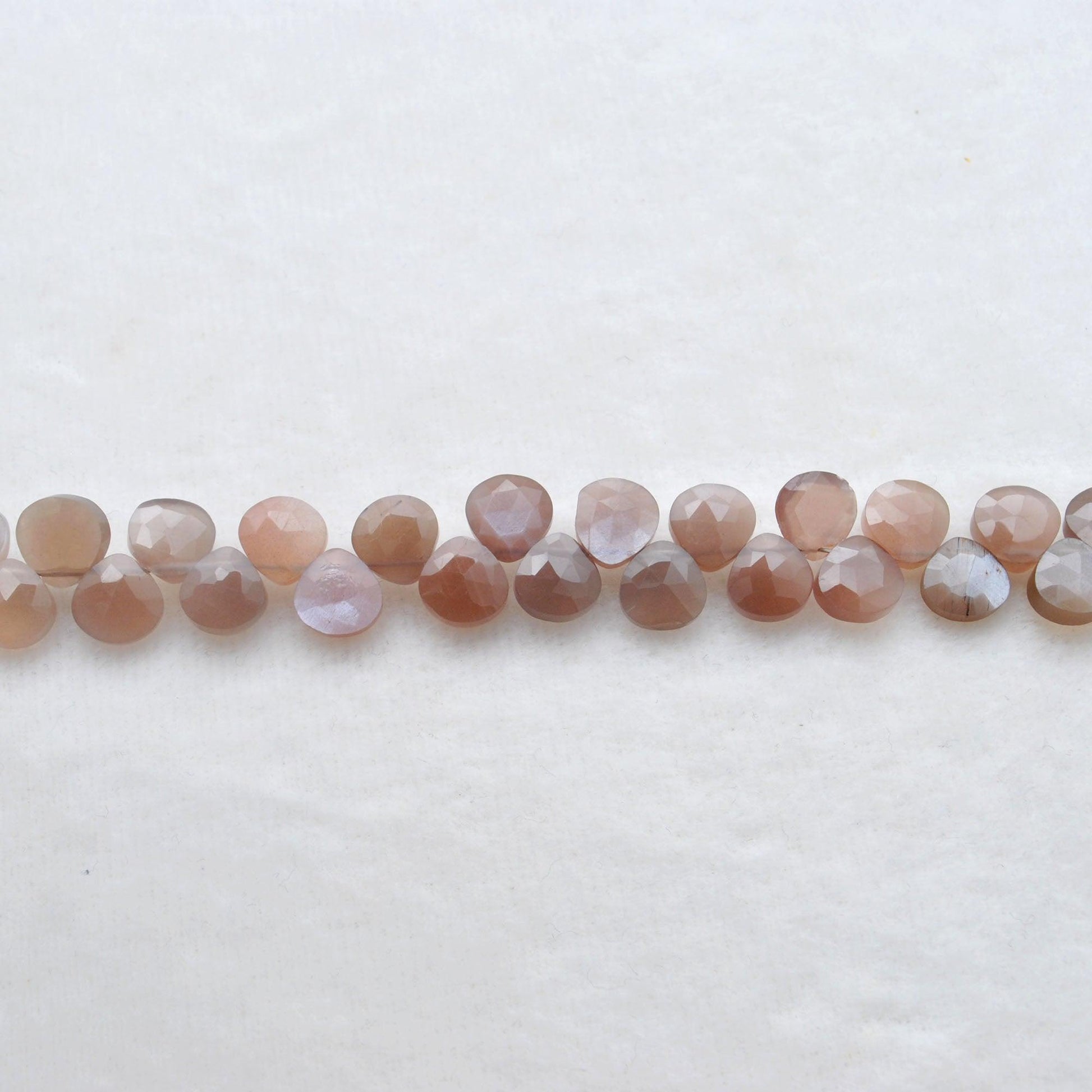 Natural chocolate moonstone heart beads - overhead flat lay warm