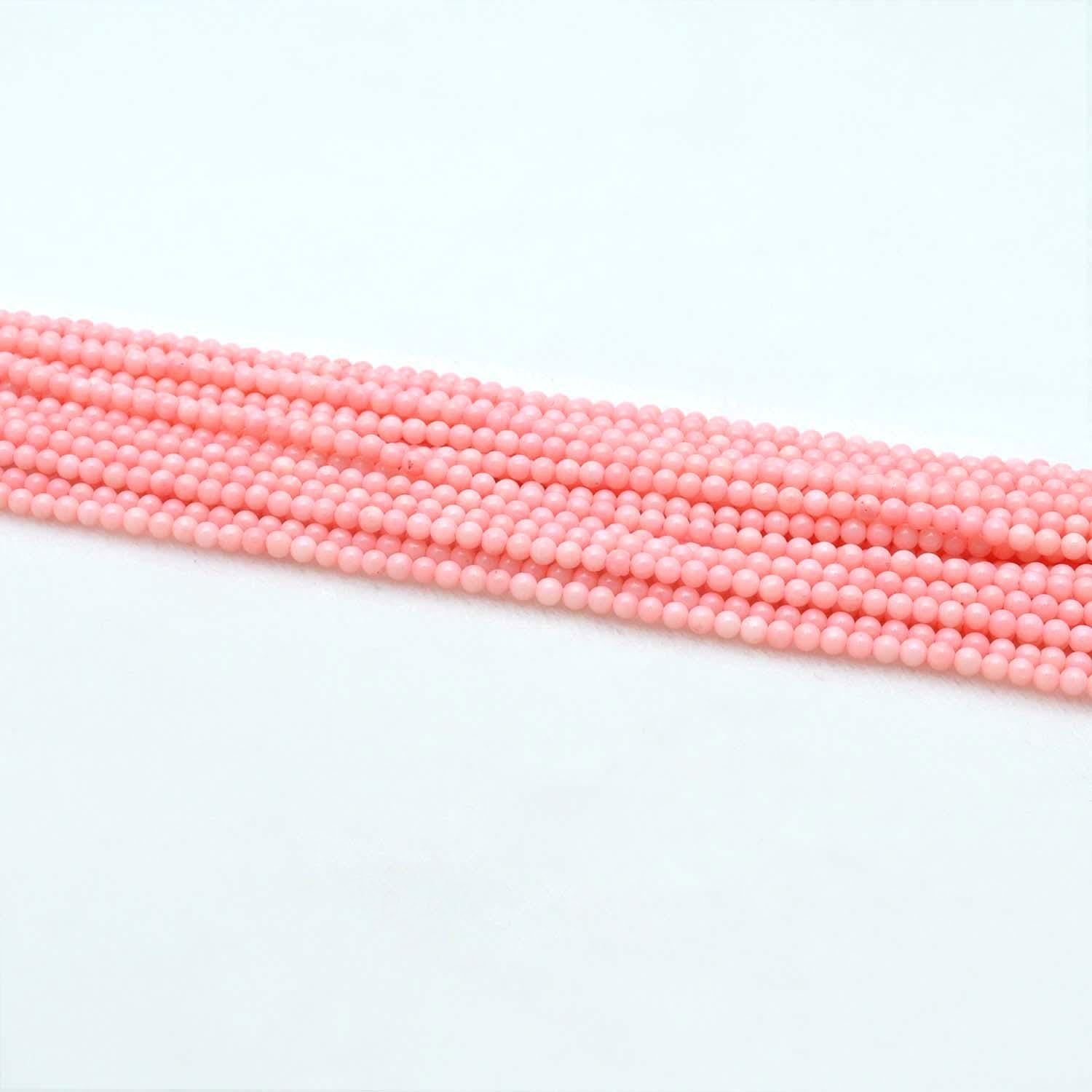 Pink coral plain round beads 12.5 inch strand overhead flat lay