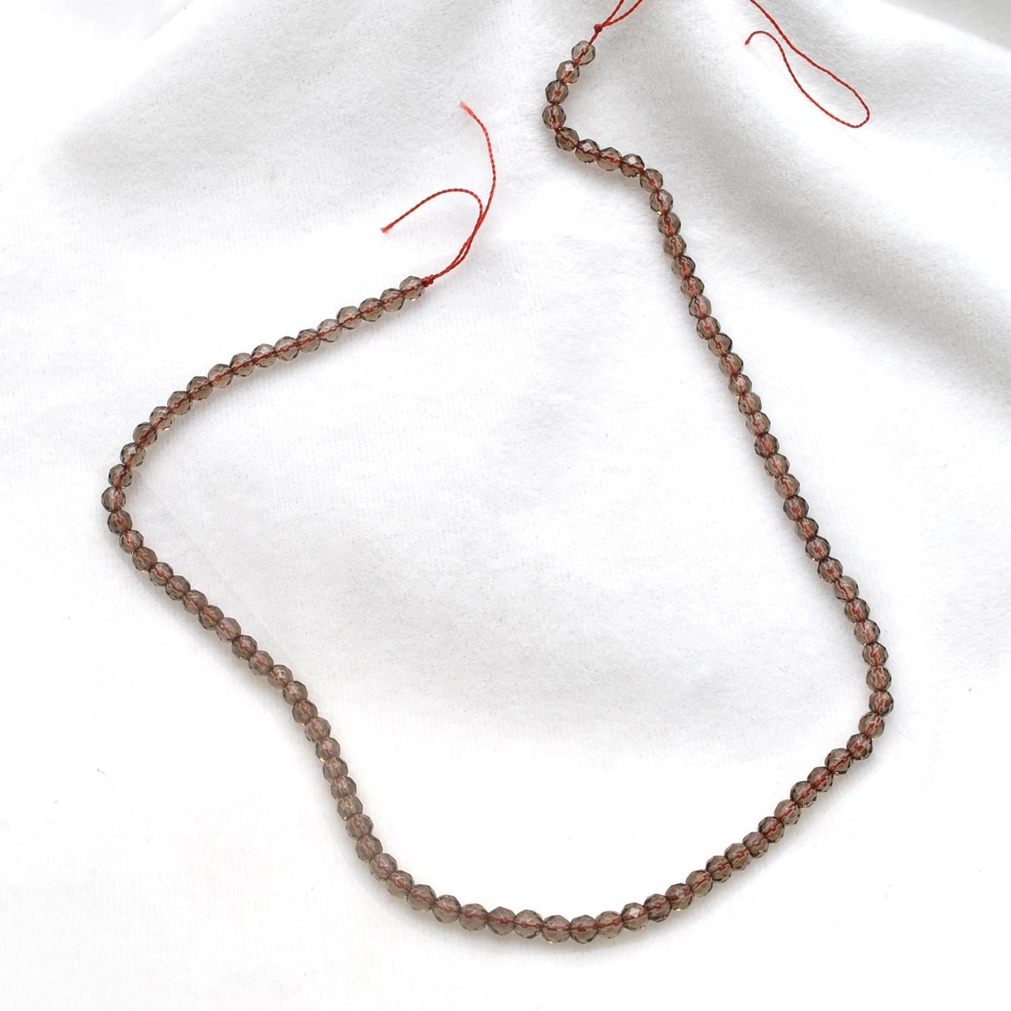Smoky quartz faceted round beads 15 inch strand overhead flat lay