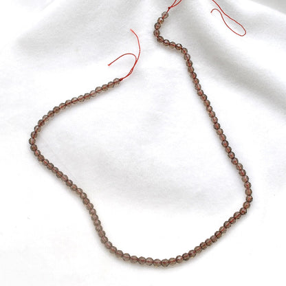 Smoky quartz faceted round beads 15 inch strand overhead flat lay