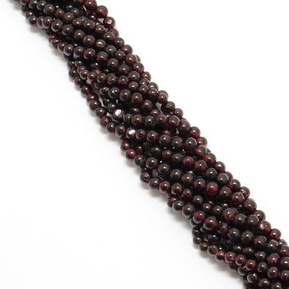 Rhodolite garnet round beads close-up uniform pinkish-red colour