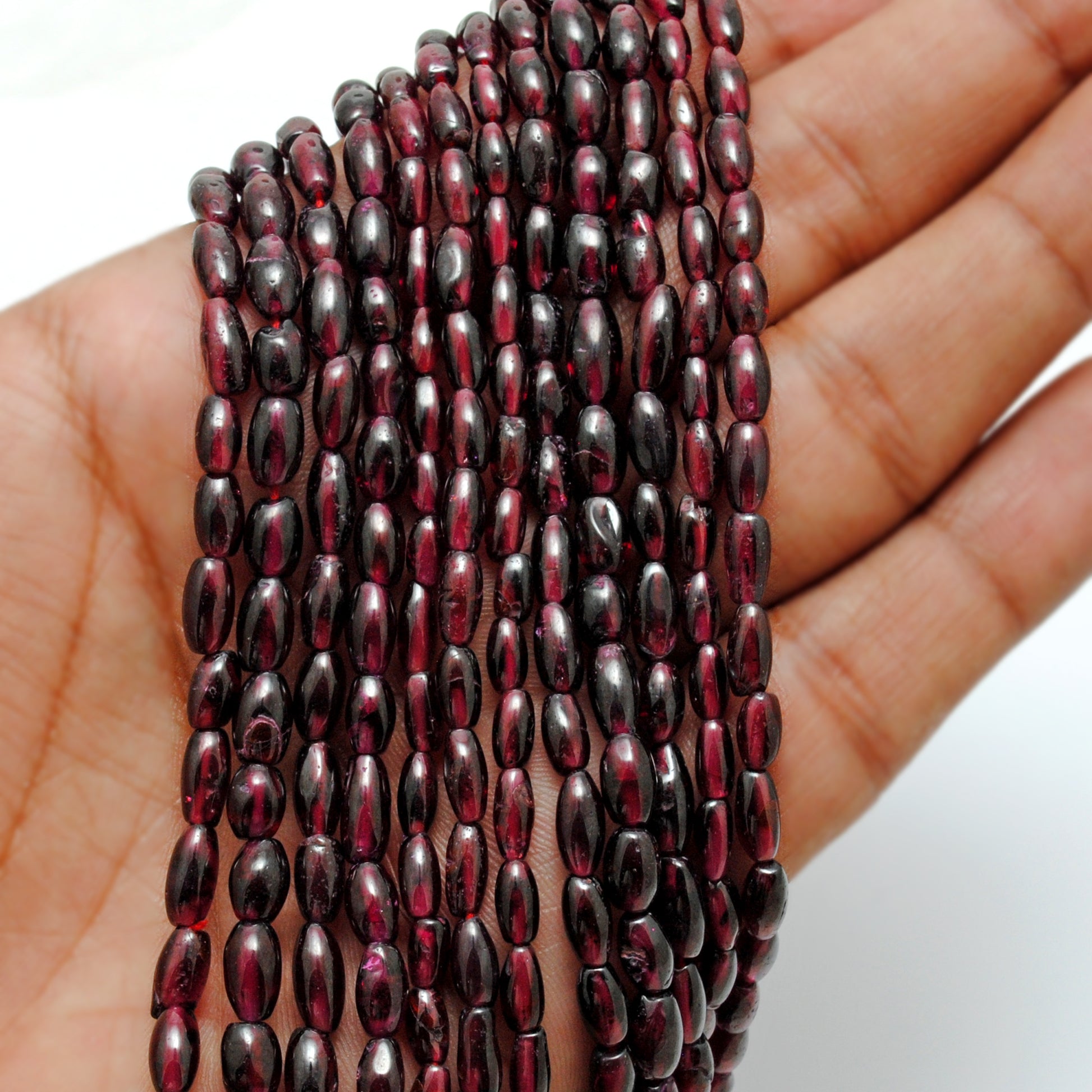 Rhodolite garnet drum beads close-up mixed sizes pinkish-red