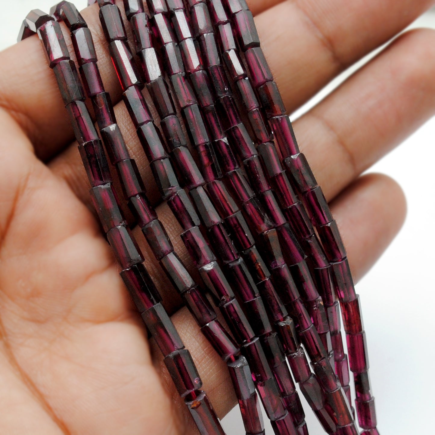 Rhodolite garnet tube beads close-up pinkish-red architectural shape
