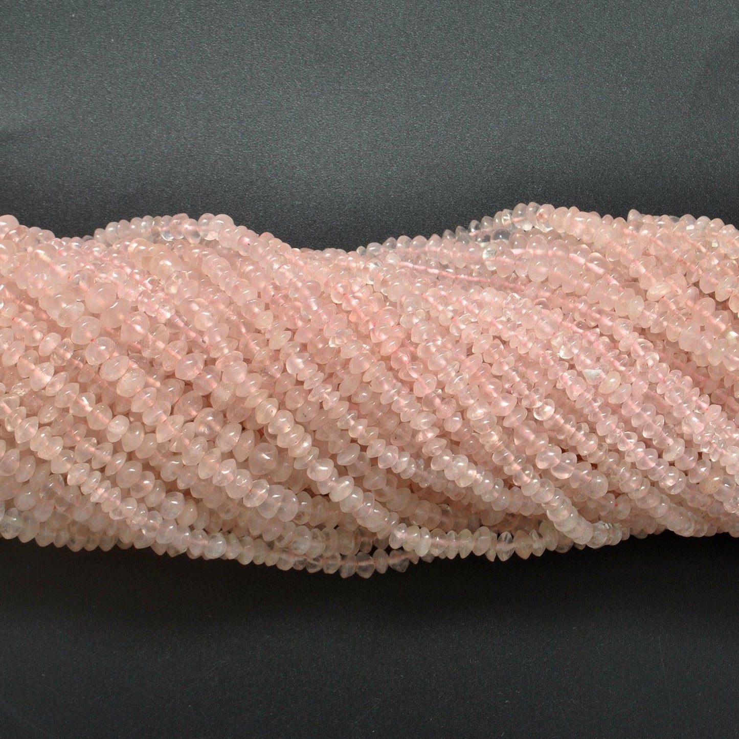 Rose quartz button beads scattered loose - flat button shape view