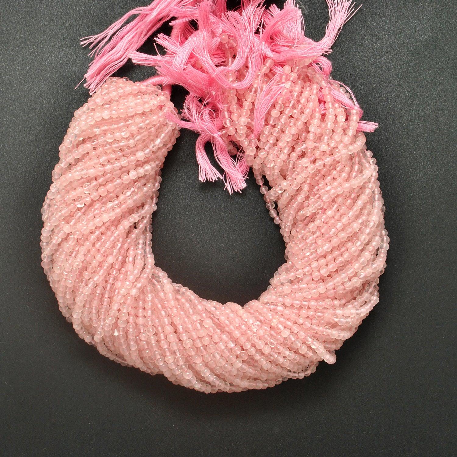 Rose quartz plain round beads scattered loose - classic shape view