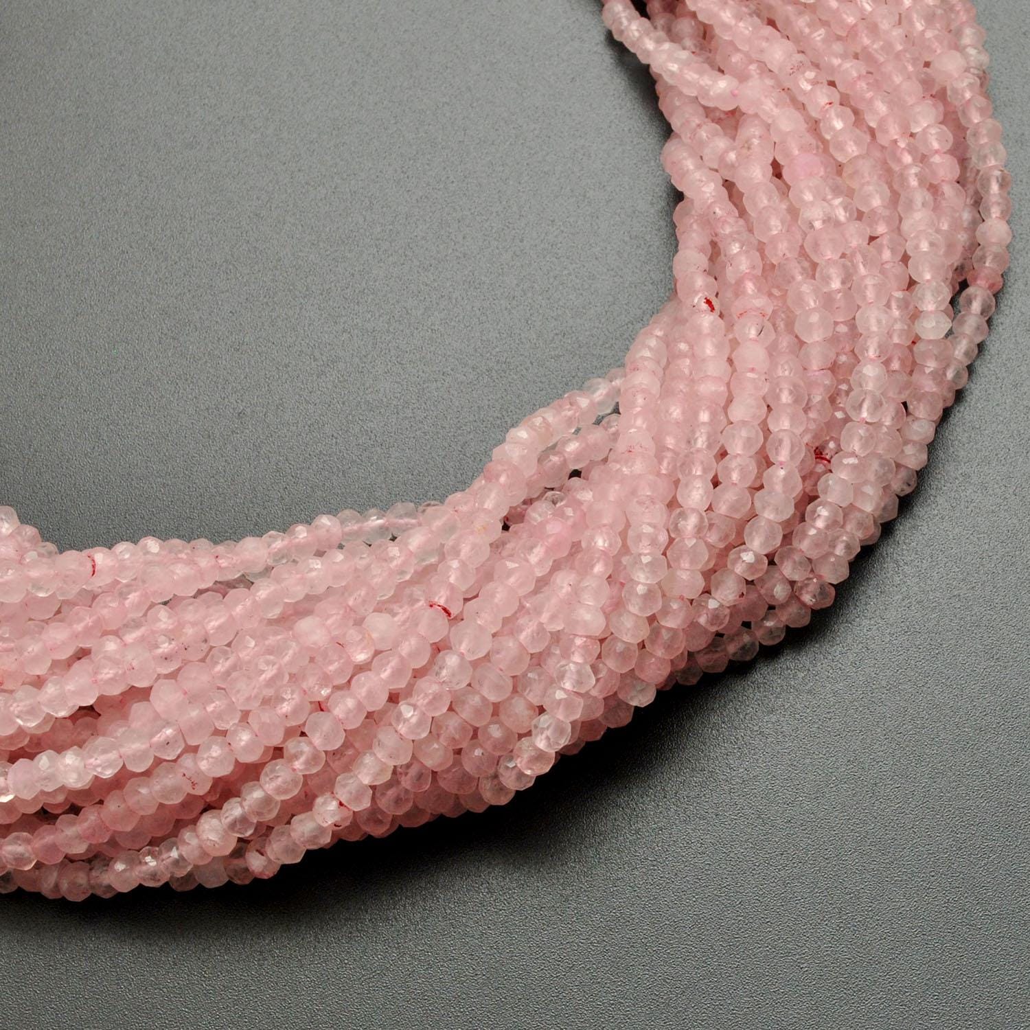 Rose quartz rondelle beads scattered loose - faceted shape view