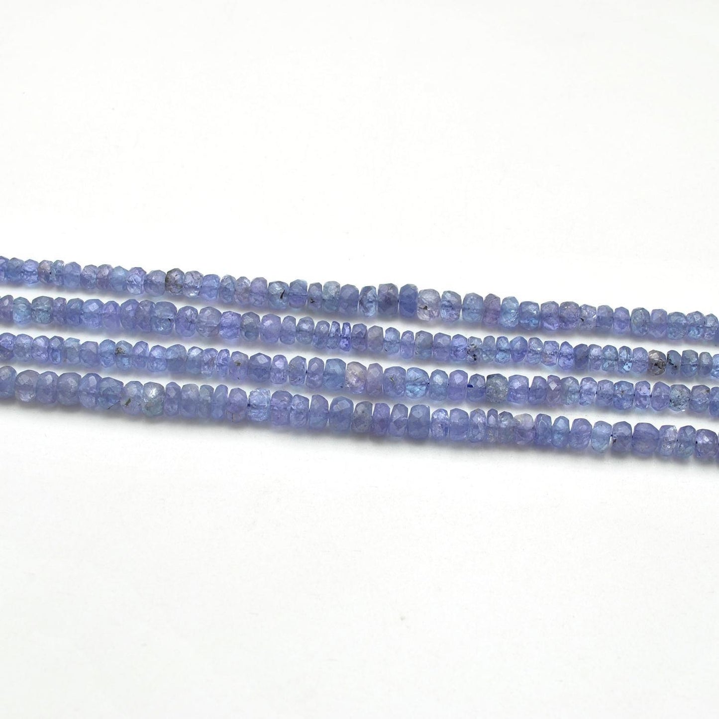 Tanzanite rondelle beads scattered loose - rare violet-blue view