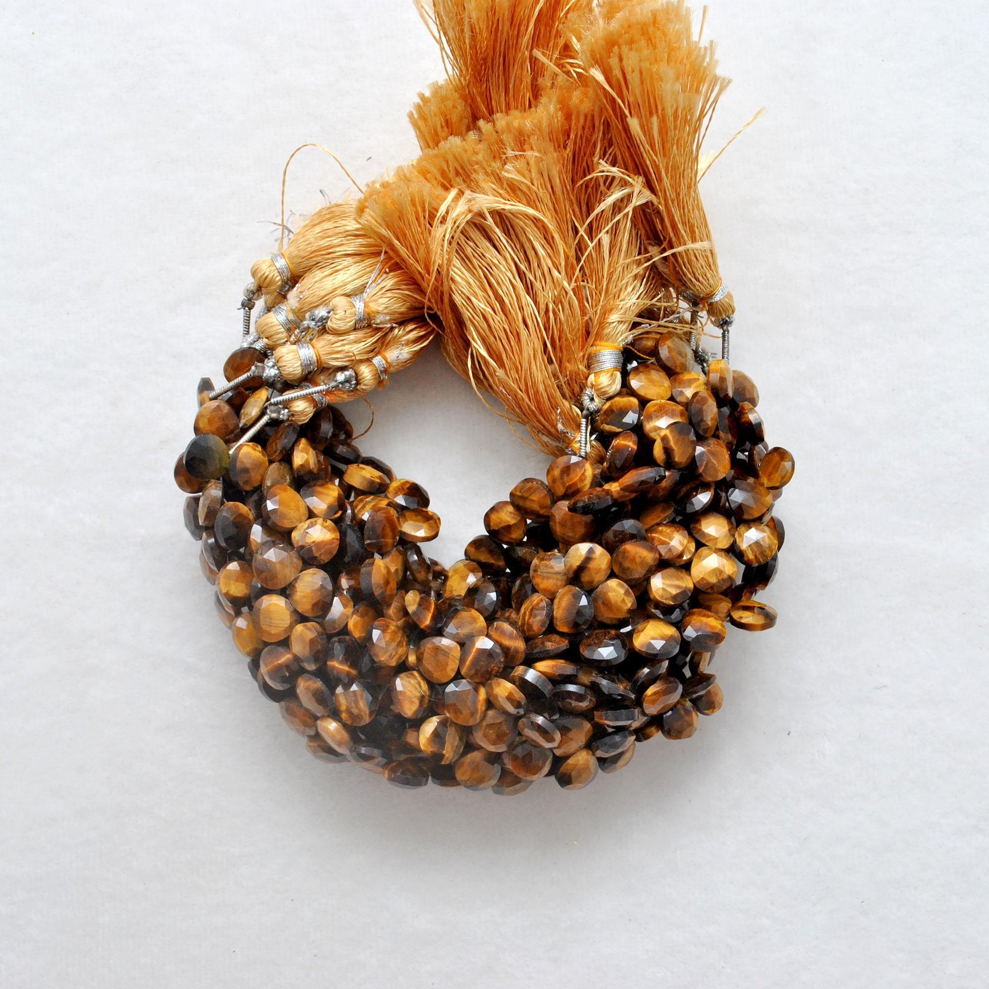 Tiger eye faceted heart beads close-up golden chatoyancy shimmer