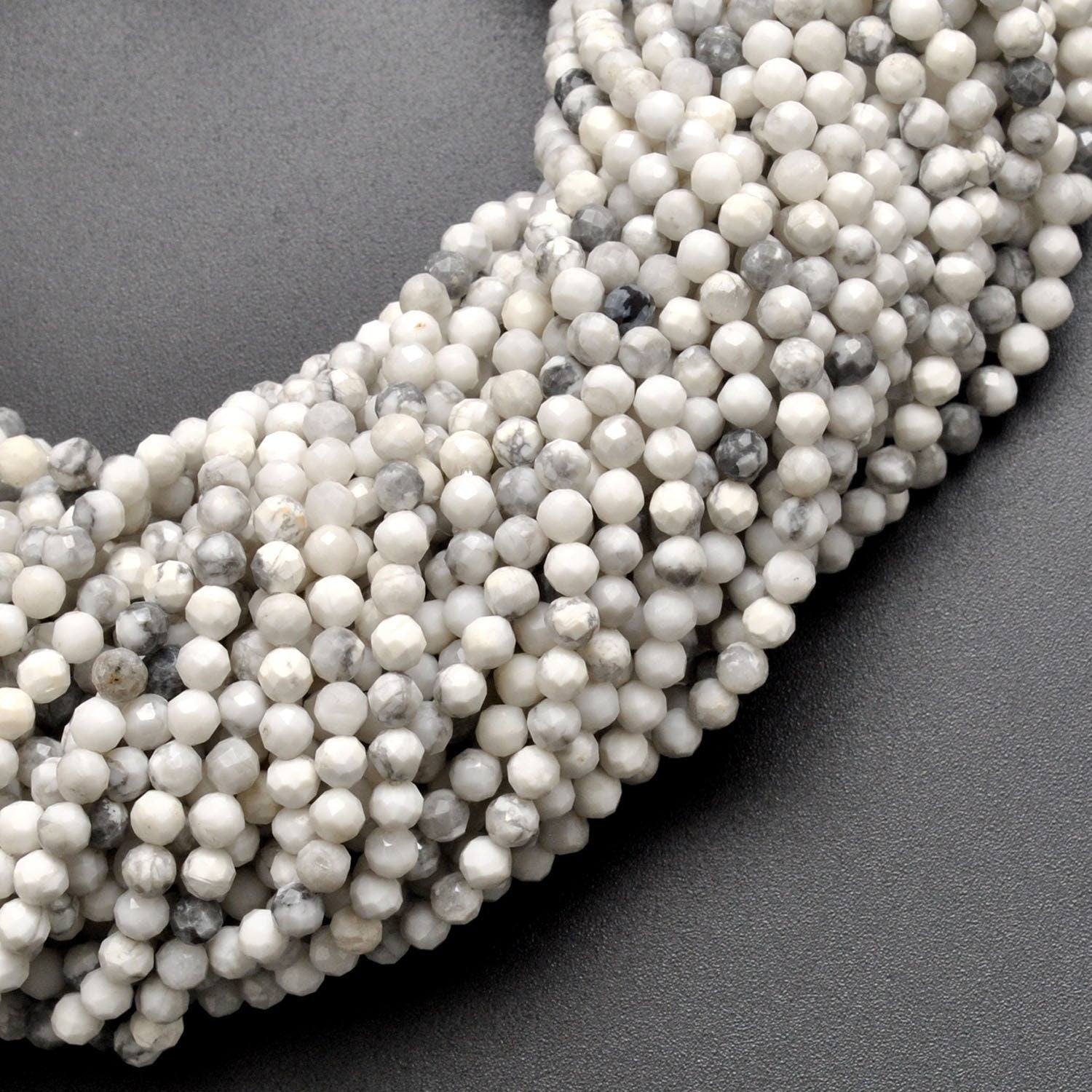 White howlite faceted round beads close-up chalk-white grey veining